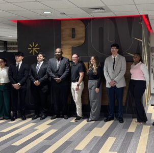 Nine students pose together.