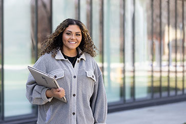 A PNW student holding her laptop outdoors