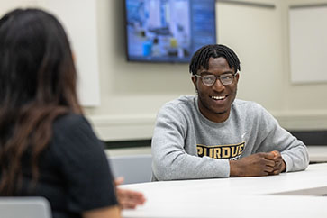 A PNW student sits at a table