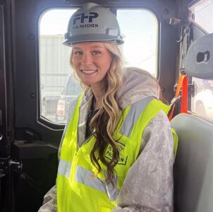 Shelby Noonan sits in safety gear and hardhat in a truck