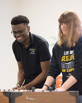Two students playing a game in housing