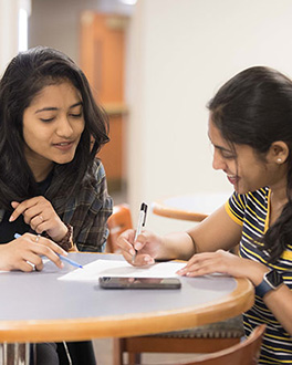 Two students working on writing something in the Writing Center