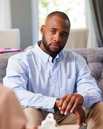A man sits in a therapist's office