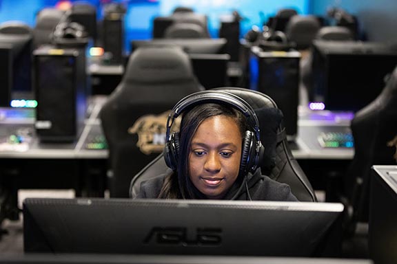 A student in headphones sits in a computer lab.