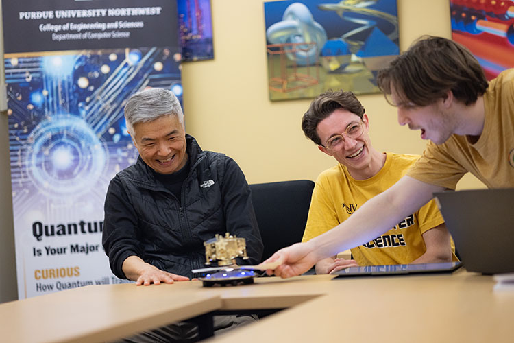 Three people work on a Quantum Club project.