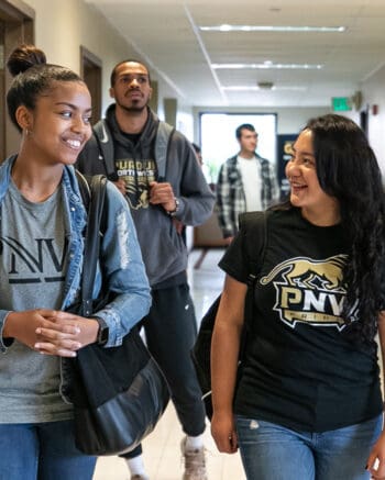 Students walking in the hall are pictured.