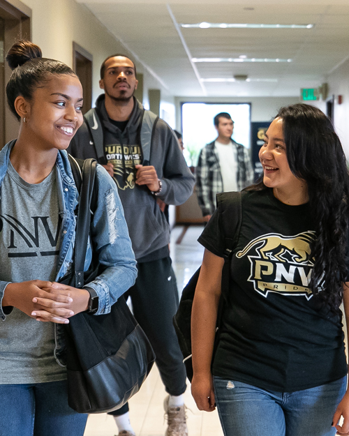 Students walking in the hall are pictured.