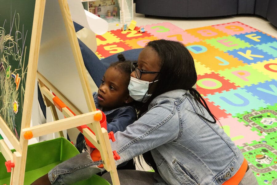 PNW student Amani Norwood, right, draws on a board with her daughter, Milani Canty, during an open house at the student-family lounge in the Classroom Office Building on the Hammond campus.