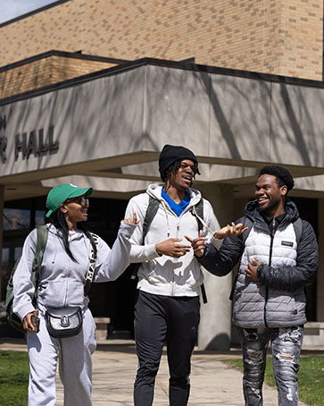 Three students walk together outdoors