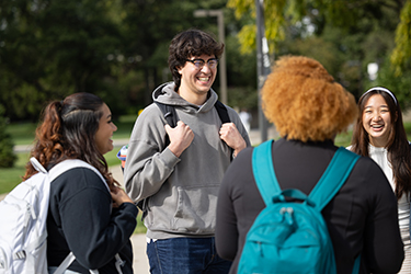 Four students stand together outside.