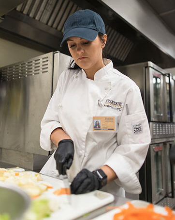 PNW Student chopping a carrot