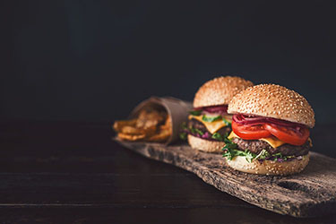 two mouth-watering, delicious homemade burger used to chop beef. on the wooden table.