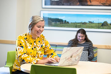 A PNW student works in a conference room