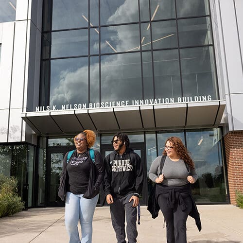 Three PNW students walk together outside of the Nils building.