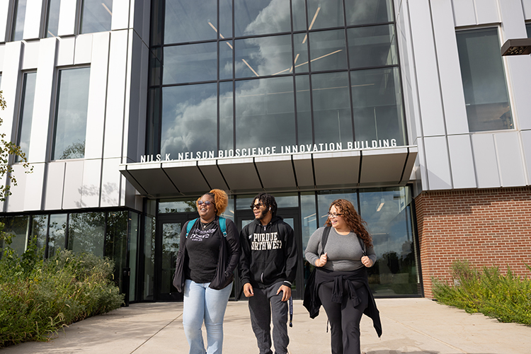 Three PNW students walk together outside of the Nils building.