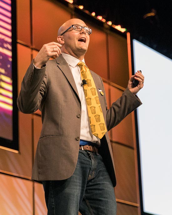 Matt Miller speaks on stage at a conference