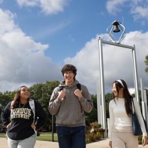 PNW students walk in front of the Bell Tower on campus.