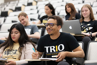 Students sit in a tiered classroom.