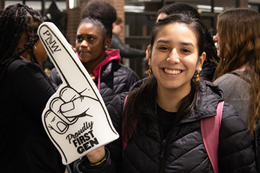 A student holds up a "Proudly First-Gen" foam finger.