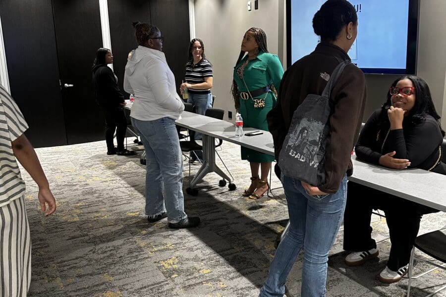 two students speaking to two older women.