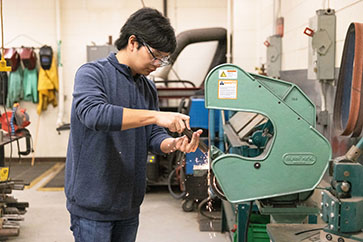 A student works with some industrial machinery