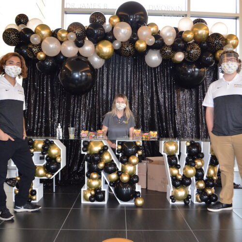 Students standing in front of PNW swag.