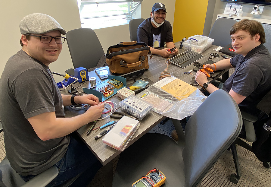 three students working on project in design studio conference room