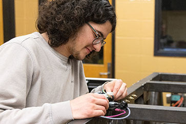 Engineering students work on a simulated steel bridge