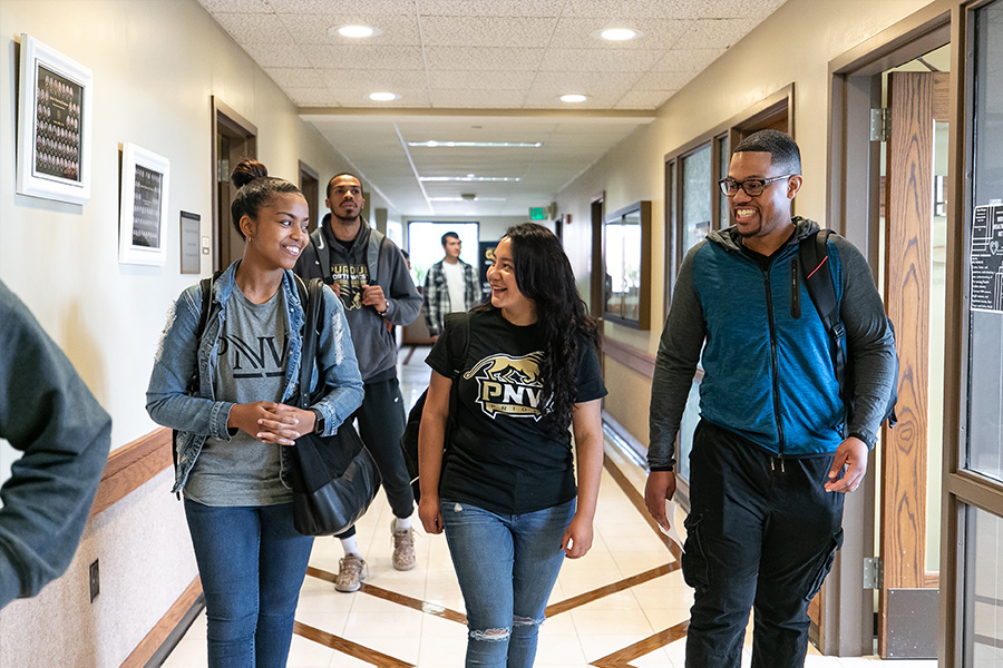 Students are pictured walking down a hall.