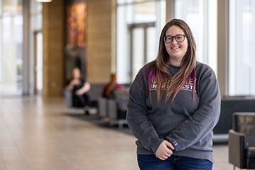 A Purdue Northwest student stands in the foyer at the Dworkin Student Services and Activities Complex