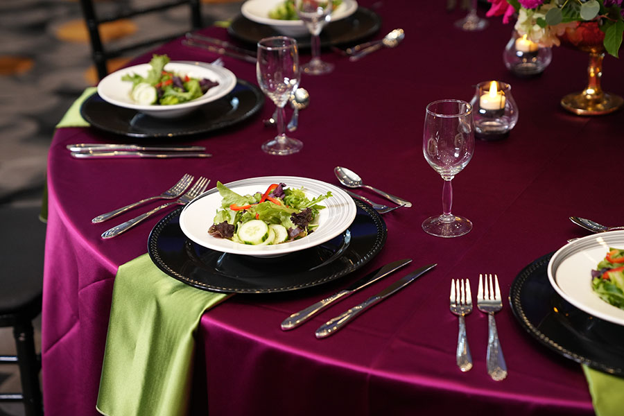 A salad course on a burgundy tablecloth at the Great Hall Events and Conference Center.