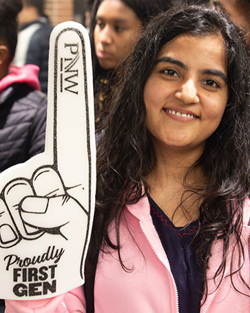 A PNW student holds up a "Proudly First Gen" foam finger.