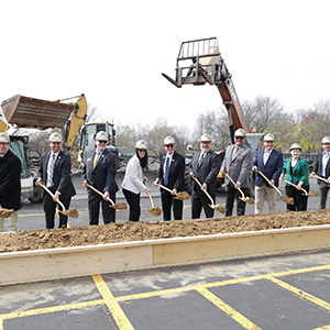 People shovel dirt during a ground breaking ceremony