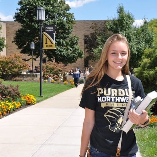 A student is smiling on campus.