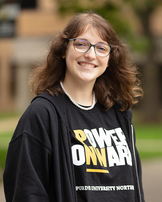 A PNW student in glasses in a Power Onward t-shirt.