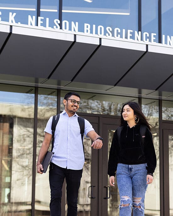 Two students walking out of a building