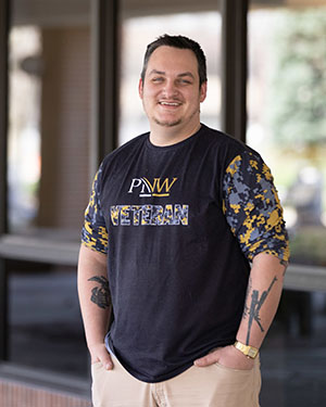 Student poses in a "PNW Veteran" t-shirt