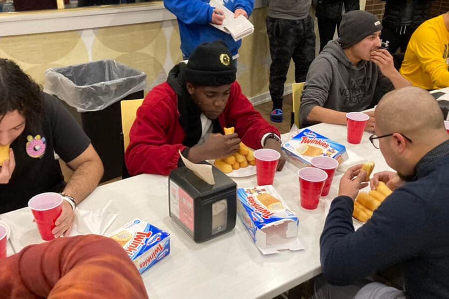 Students sitting around a table eating twinkies