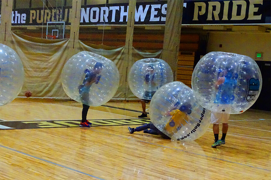 Five students playing bubble soccer