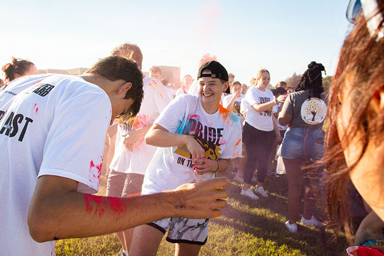 Two students throw color powder at each other