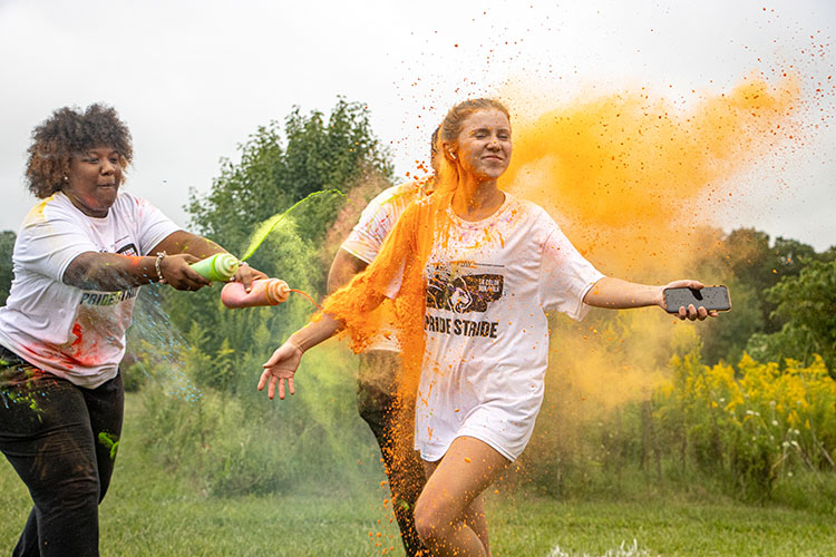 A student runs through a cloud of orange color powder