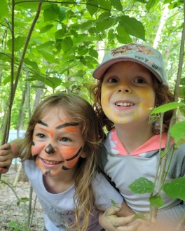 Kids in face paint play in the gardens at Gabis Arboretum