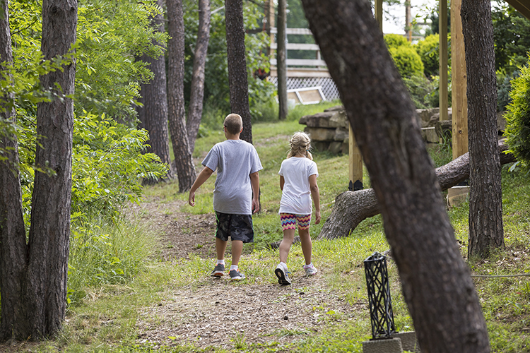 Two children walk down a path at Gabis Arboretum