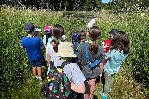 Students stand together in a group on a trail.