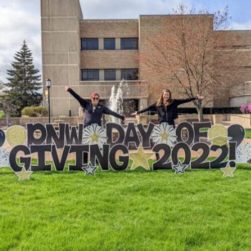 PNW students pose near a PNW Day of Giving 2022 Yard Sign