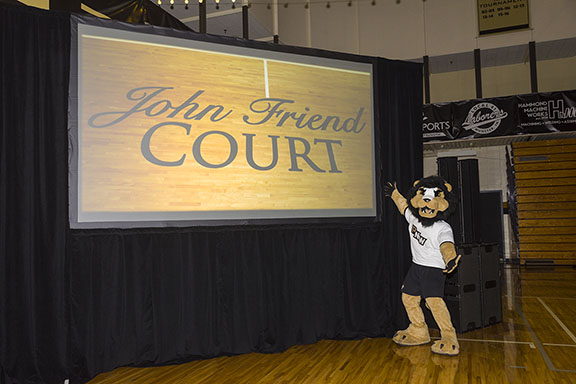 PNW mascot Leo stands in front of a sign announcing the John Friend Court