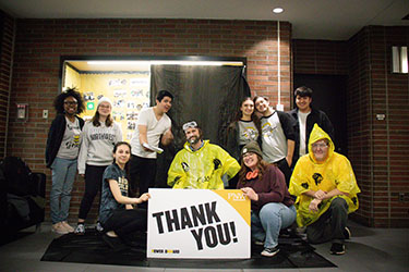 Ten people pose together behind a PNW branded "Thank You" sign