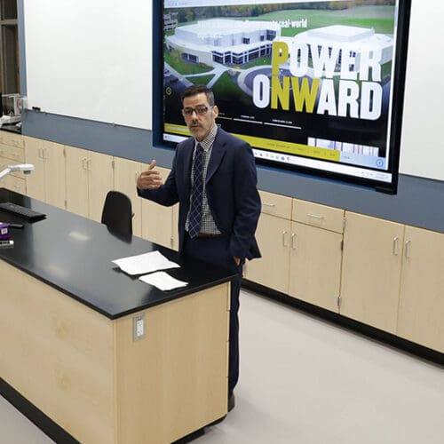 Dean Sanchez stands at the front of a lab space