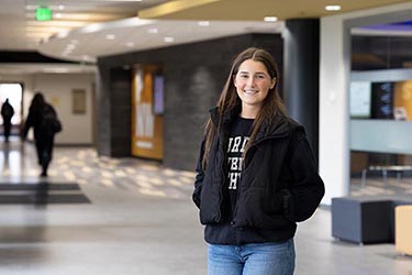 A PNW student stands in the Mane Zone on campus
