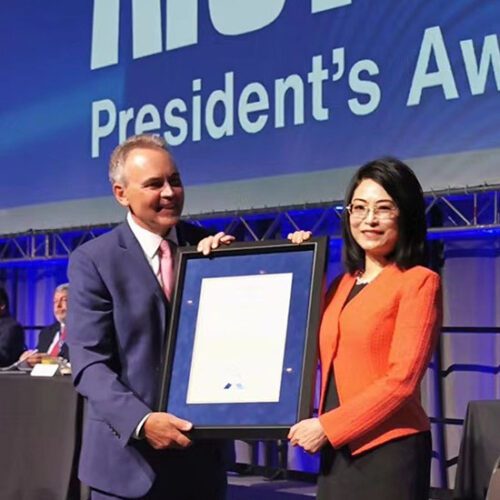 CIVS Director Chenn Zhou poses with another person and a framed award certificate